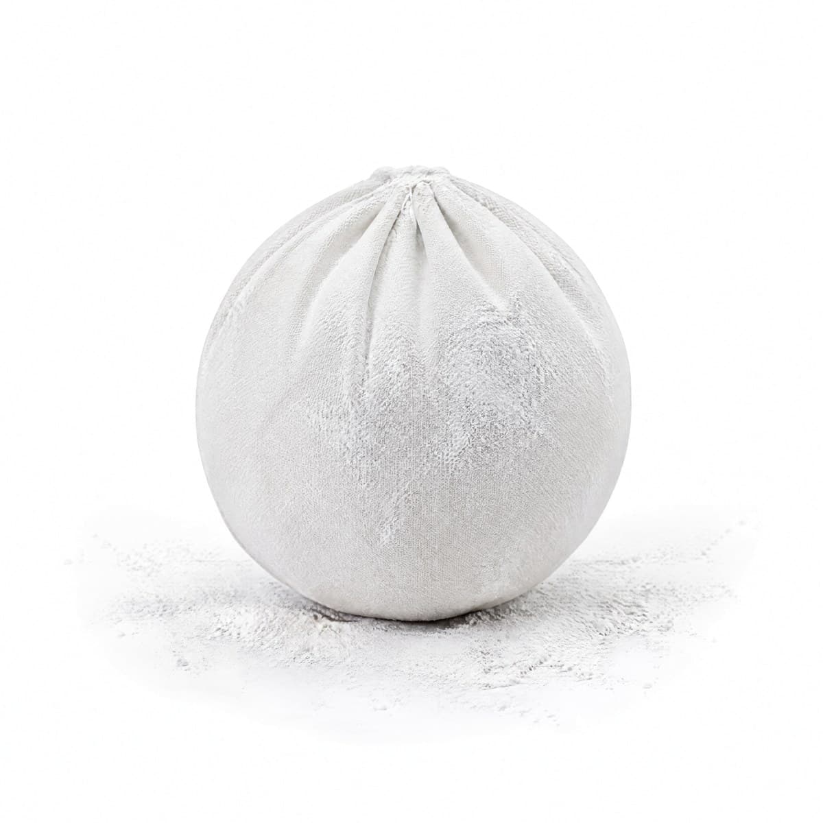 A white cloth chalk ball gathered at the top, with loose chalk dust around it